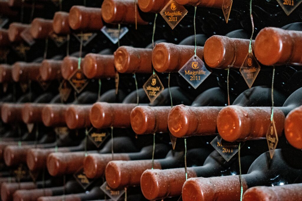 Rows of vintage 2011 wine bottles stored horizontally in a dimly lit cellar.