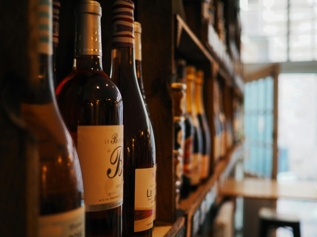 Close-up of wine bottles on shelves in a cozy bar setting in Lille, France.