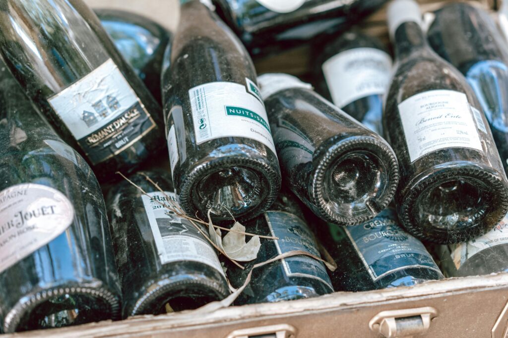A collection of empty wine and champagne bottles in a case, ready for recycling.